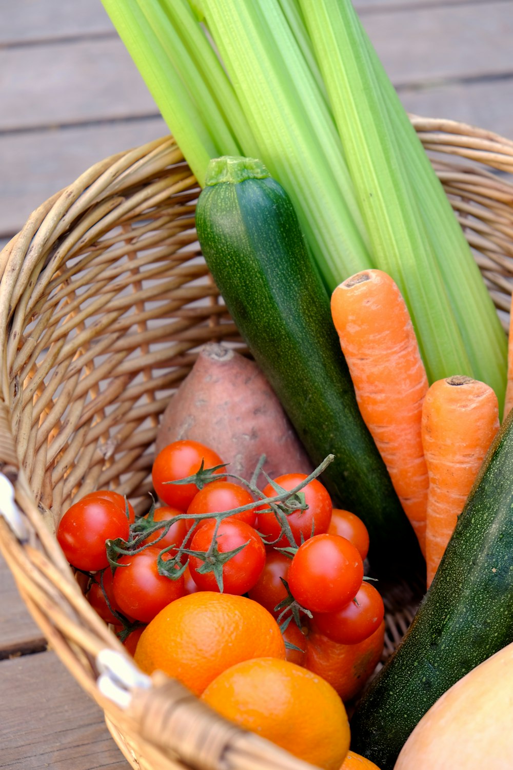 Basket of carrots, cucumbers and cherry tomatoes